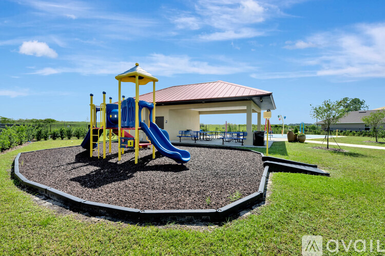 A playground with a yellow structure and a blue slide.