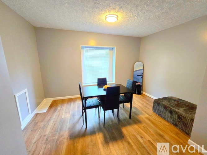 A room with a dining table and chairs.