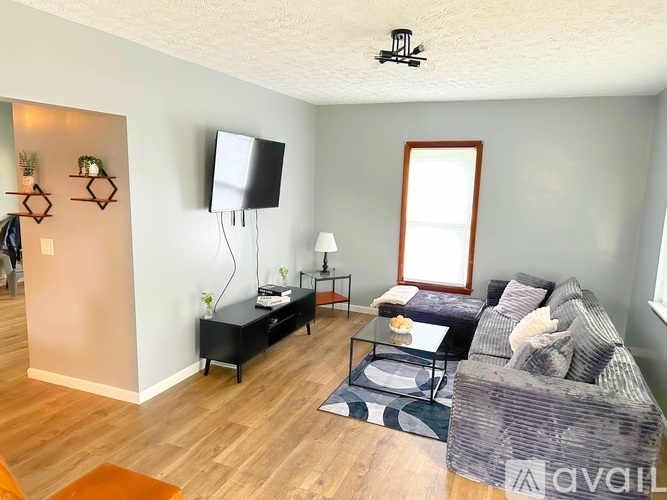 A living room with a grey couch and a black coffee table.