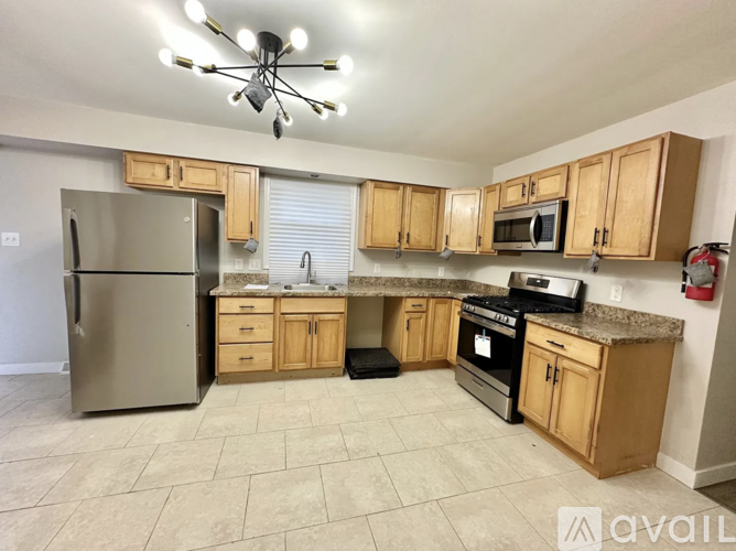 A kitchen with wooden cabinets and a stainless steel refrigerator.