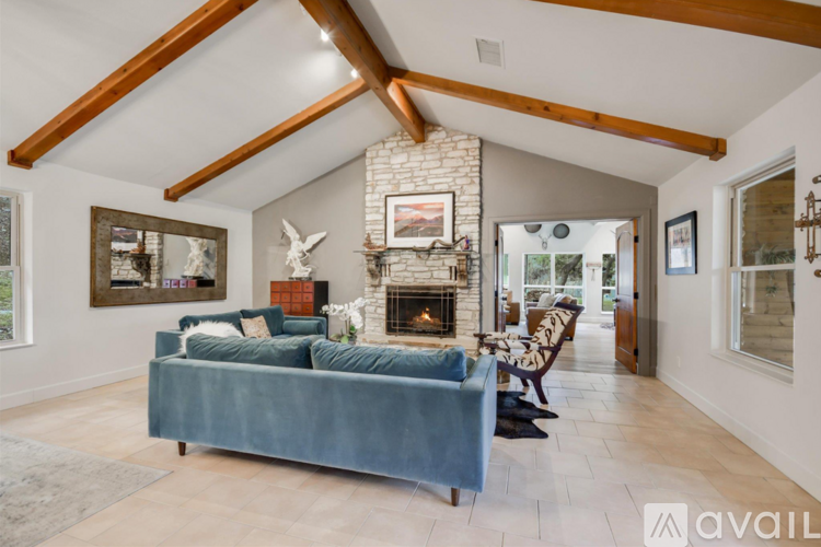 A living room with a blue couch and a fireplace.