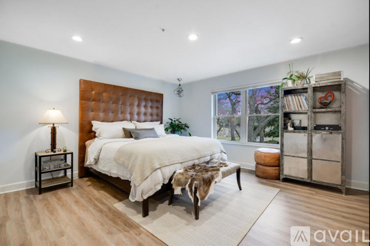 A bedroom with a large bed and a wooden headboard.