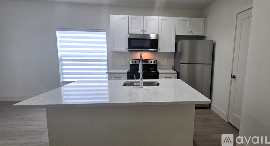 A kitchen with a white countertop and a stove top oven.