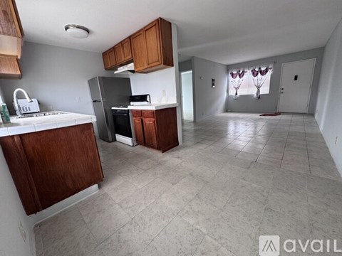A kitchen with wooden cabinets and a black refrigerator.