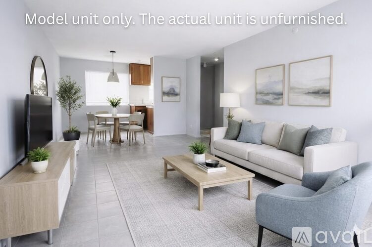 A well-lit, modern living room with a dining area and a kitchenette.