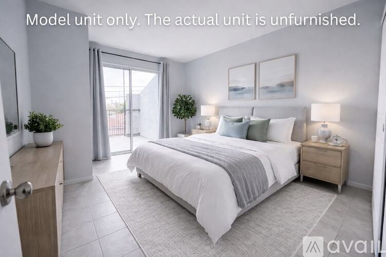 A well-lit, spacious bedroom with a large bed, two nightstands, and a sliding glass door.