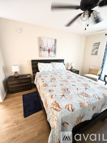 A bedroom with a bed, nightstand, and a ceiling fan.