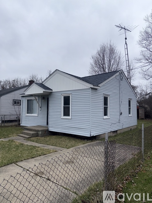 A small house with a fence in front of it.