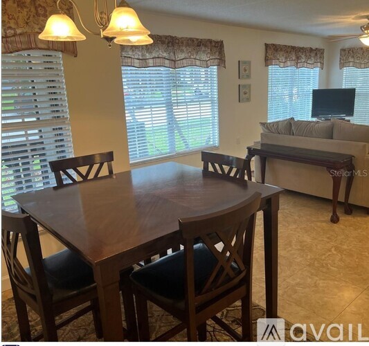 A dining room with a wooden table and chairs.