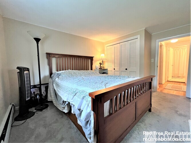 A bedroom with a bed, nightstand, and lamp.