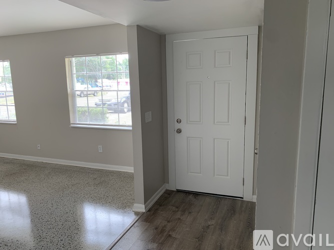 A room with a white door and a window with blinds.