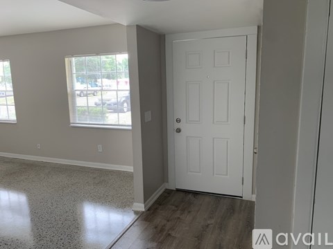 A room with a white door and a window with blinds.