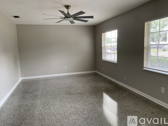A room with a ceiling fan and a window with blinds.