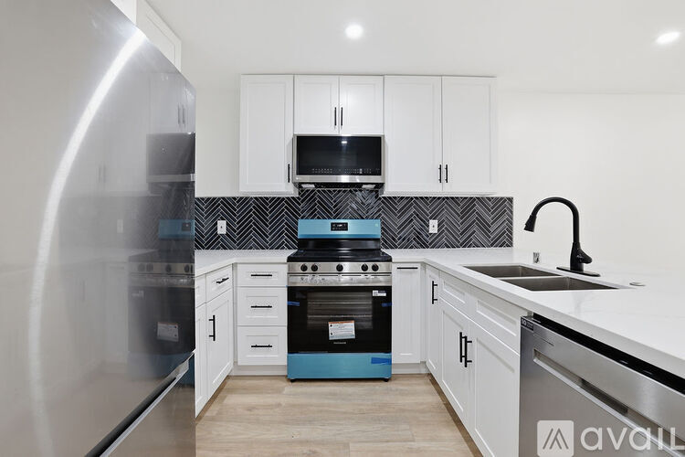A kitchen with white cabinets and a blue oven.