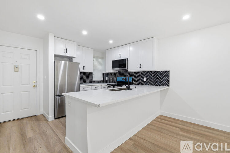 A modern kitchen with white cabinets and a central island.