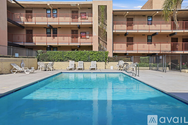 A swimming pool in front of a building with a sign that says "available".
