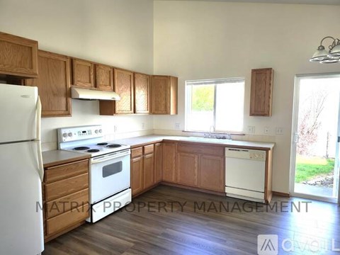 A kitchen with wooden cabinets and white appliances.