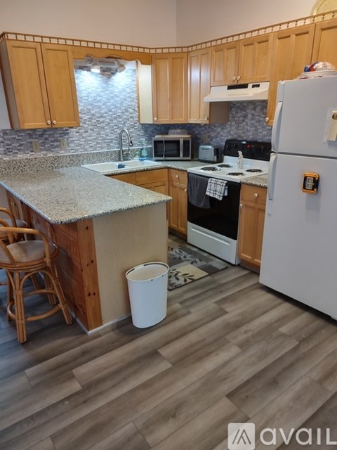 A kitchen with wooden cabinets and a white fridge.