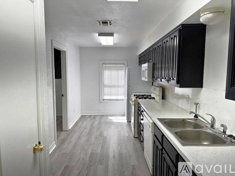 A kitchen with black cabinets and a sink.