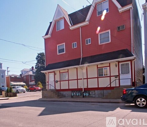 A red and white building with a car parked in front.