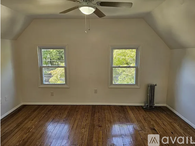 A room with wooden floors and two windows.