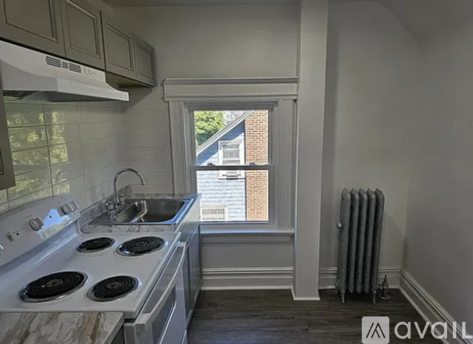 A kitchen with a stove top oven and a window.