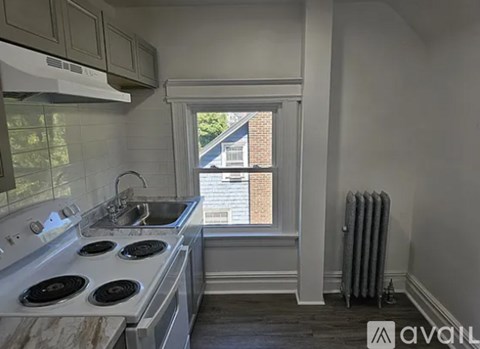 A kitchen with a stove top oven and a window.