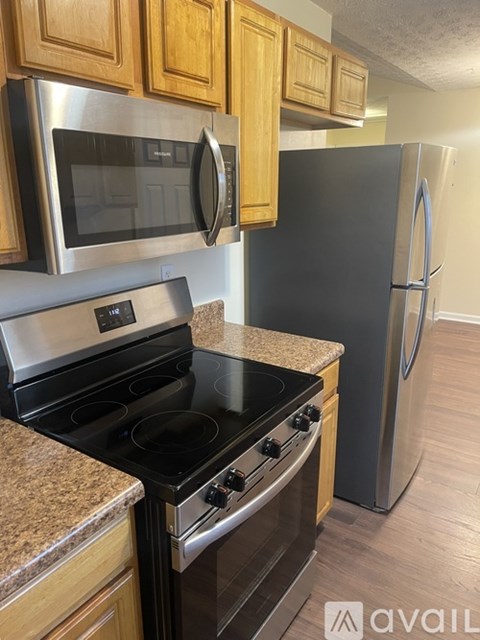 A kitchen with a black stove top oven and a black microwave above it.