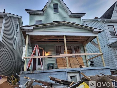 A house with a blue exterior is in the process of being demolished.