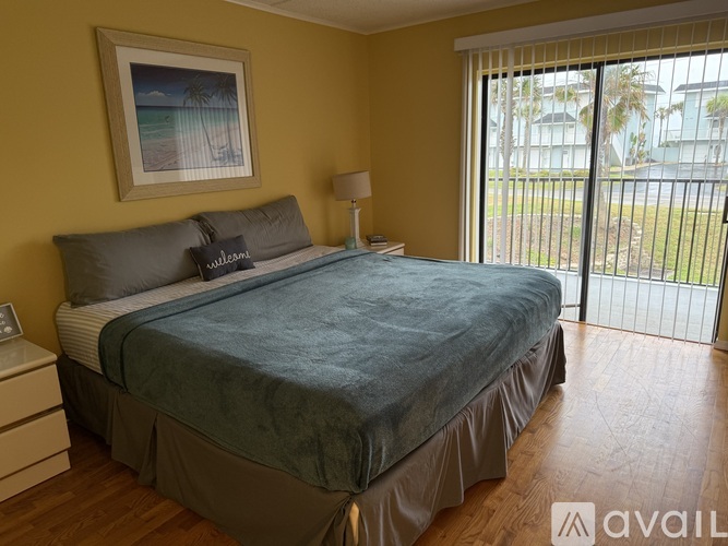 A bedroom with a bed, nightstand, lamp, and a painting on the wall.