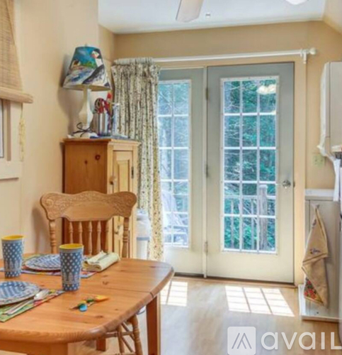 A dining room with a wooden table and chairs.