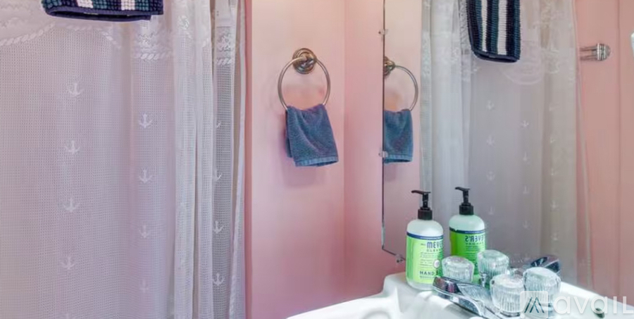 A bathroom with pink walls and a white shower curtain.