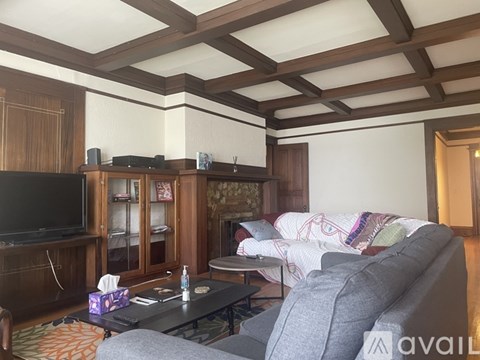 A living room with a grey couch and a wooden cabinet.