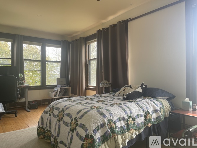 A bedroom with a large bed and a desk with a computer.