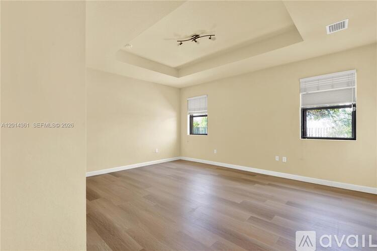 A room with a window and a fan on the ceiling.