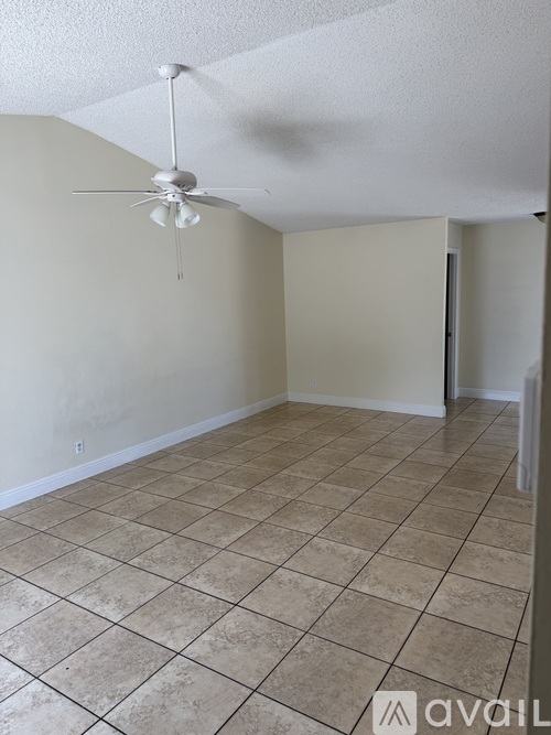 A room with a ceiling fan and tiled flooring.