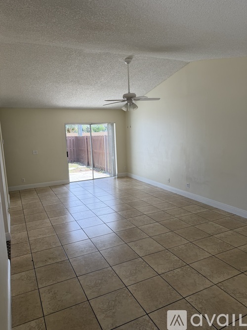 A room with a ceiling fan and tile flooring.