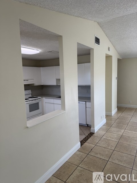 A kitchen with white cabinets and a window.