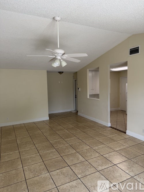 A room with a ceiling fan and tile flooring.