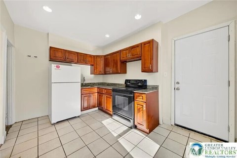 A kitchen with white appliances and wooden cabinets.
