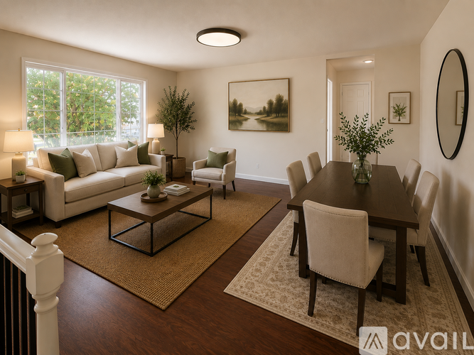 A living room with a white couch, a coffee table, and a dining table with chairs.