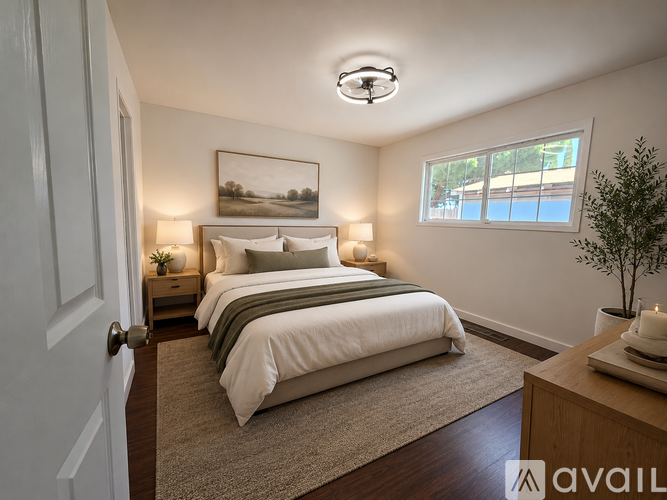 A bedroom with a large bed and a painting on the wall.