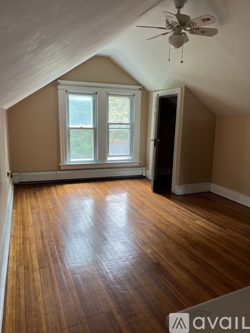 A room with wooden flooring and a ceiling fan.