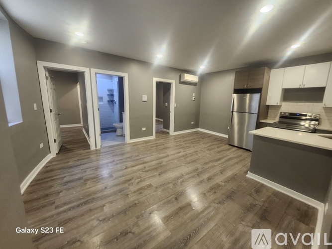 A kitchen area with a refrigerator, stove, and cabinets.