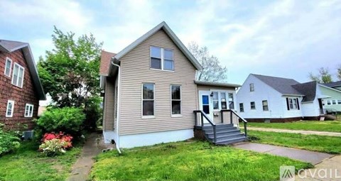 A house with a front yard and a tree.