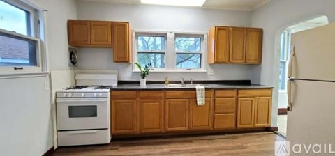 A kitchen with wooden cabinets and a white stove top oven.