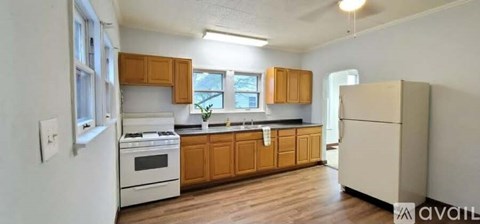 A kitchen with wooden cabinets and a white refrigerator.