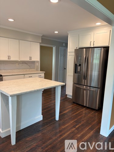 A kitchen with a table and a refrigerator.