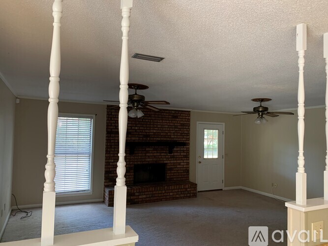 A living room with a fireplace and a ceiling fan.