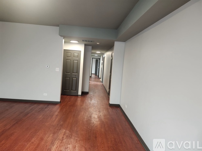 A long hallway with a wooden floor and white walls.